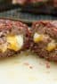 This recipe uses ground beef stuffed with cheddar cheese and shaped into a log. The beef is then wrapped by a bacon weave and smoked until cooked and gooey! Great tailgate food!