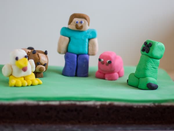 A Minecraft cake! I cheated and used figures for the top… I find kids love  to get a toy with their cake! : r/cakedecorating