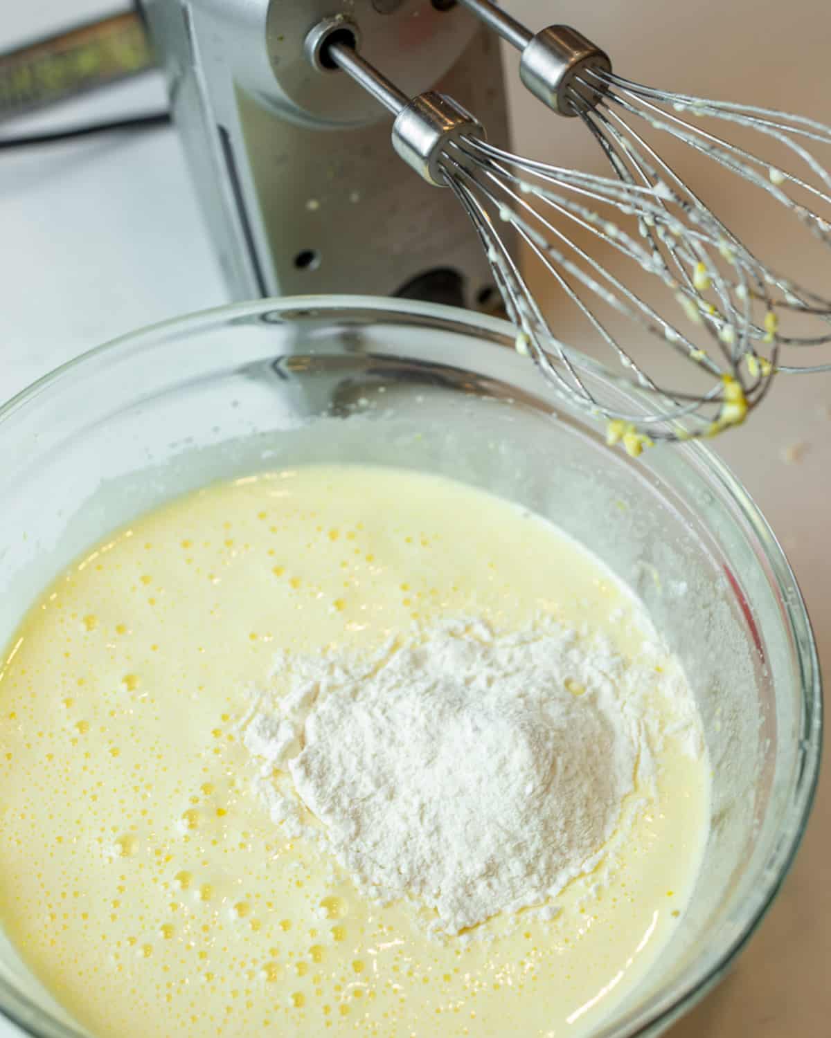 Lemon meringue mixture beaten in a glass bowl.