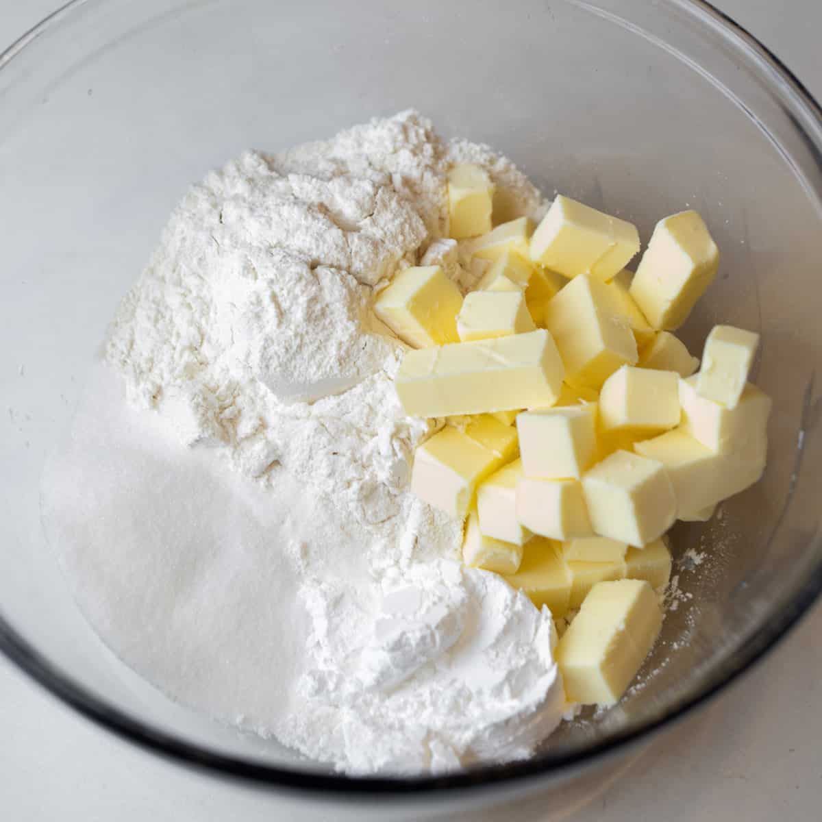Flour and butter in a glass bowl.